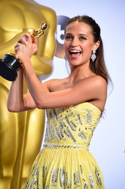 ALICIA VIKANDER – Aunque hoy, con el debate abierto sobre si sólo los actores y actrices trans pueden interpretar personajes trans, 'La chica danesa' está bajo sospecha, en 2015 fue un pequeño fenómeno. La delicada historia de amor inspirada en las vidas de los artistas daneses Lili Elbe y Gerda Wegener cosechó cuatro nominaciones al Oscar, entre ellas una para el diseñador de vestuario español Paco Delgado, aunque sólo Vikander pudo subir a recoger el suyo. En los despachos de Los Ángeles se frotaron las manos, Vikander: joven, guapa y excelente actriz, encarnaba el tipo de diva que en los años treinta había llegado a Hollywood para aportar clase y glamour, las Garbo y Dietrich que habían reinado y revitalizado las taquillas durante una década. ¿Qué pasó después del Oscar? Aquel año Vikander también había estado espléndida por su cibernético papel en 'Ex-Machina' y venía de participar en la exquisita 'Anna Karenina' y en la también nominada 'Un asunto real'. No era una desconocida para la crítica y su trayectoria dejaba claro que su brillante actuación en 'La chica danesa' no era una casualidad, pero sus elecciones posteriores no estuvieron acordes con lo que se esperaba de ella. Participó en taquillazos como 'Jason Bourne' y 'Operación U.N.C.L.E.' y fue elegida para sustituir a Angelina Jolie como 'Lara Croft', pero la idea de convertirla en una heroína de acción no cuajó. Parece mucho más cómoda en proyectos más personales como la versión televisiva de 'Irma Veep' de Olivier Assayas y llevando una vida tranquila en Lisboa junto a su marido Michael Fassbender. Habrá quien diga que bendita sea la maldición del Oscar sí implica un matrimonio con el germanoirlandés.