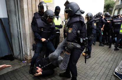 Dos policías desalojan la entrada a un colegio el día 1 de octubre.