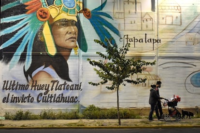 Una familia pasea junto a un mural en Iztapalapa por la noche. I.G.