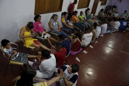 Internos realizan el masaje de ayurveda de pies a sus familiares durante una visita de mediodía del programa ACUDA, el 28 de agosto de 2015. Ayurveda es un método hindú antiguo de curación holística.