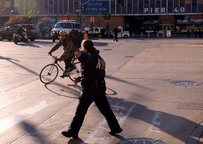 En la imagen, un agente dirige a un ciclista fuera de la zona del tiroteo.