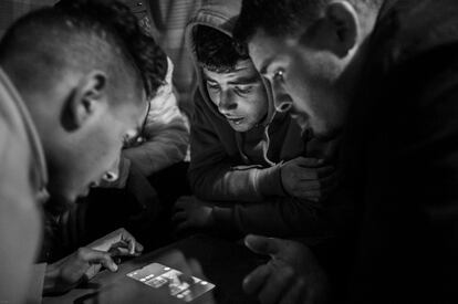 14 de febrero de 2023. San isidro de Nijar (Almería). Reda, Hamza y Mohammed juegan con una aplicación de móvil durante la noche. Medhi no participa. Está triste porque Reda se marcha en una semana.  