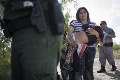 Una madre migrante sujeta a su niña en brazos en el momento de la detención en Roma, Texas (Estados Unidos). Los migrantes son enviados a los centros de detención donde permanecen hasta 78 horas en donde se les identifica a cabalidad e inicia su proceso de reubicación.