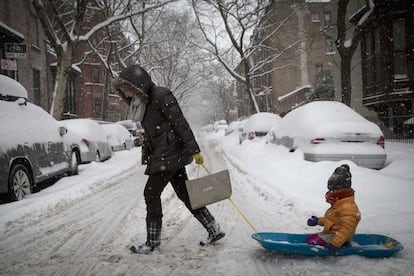 Una mujer arrastra a su hijo con un trineo en la zona de Park Slope en  Brooklyn (Nueva York), 13 de febrero de 2013.