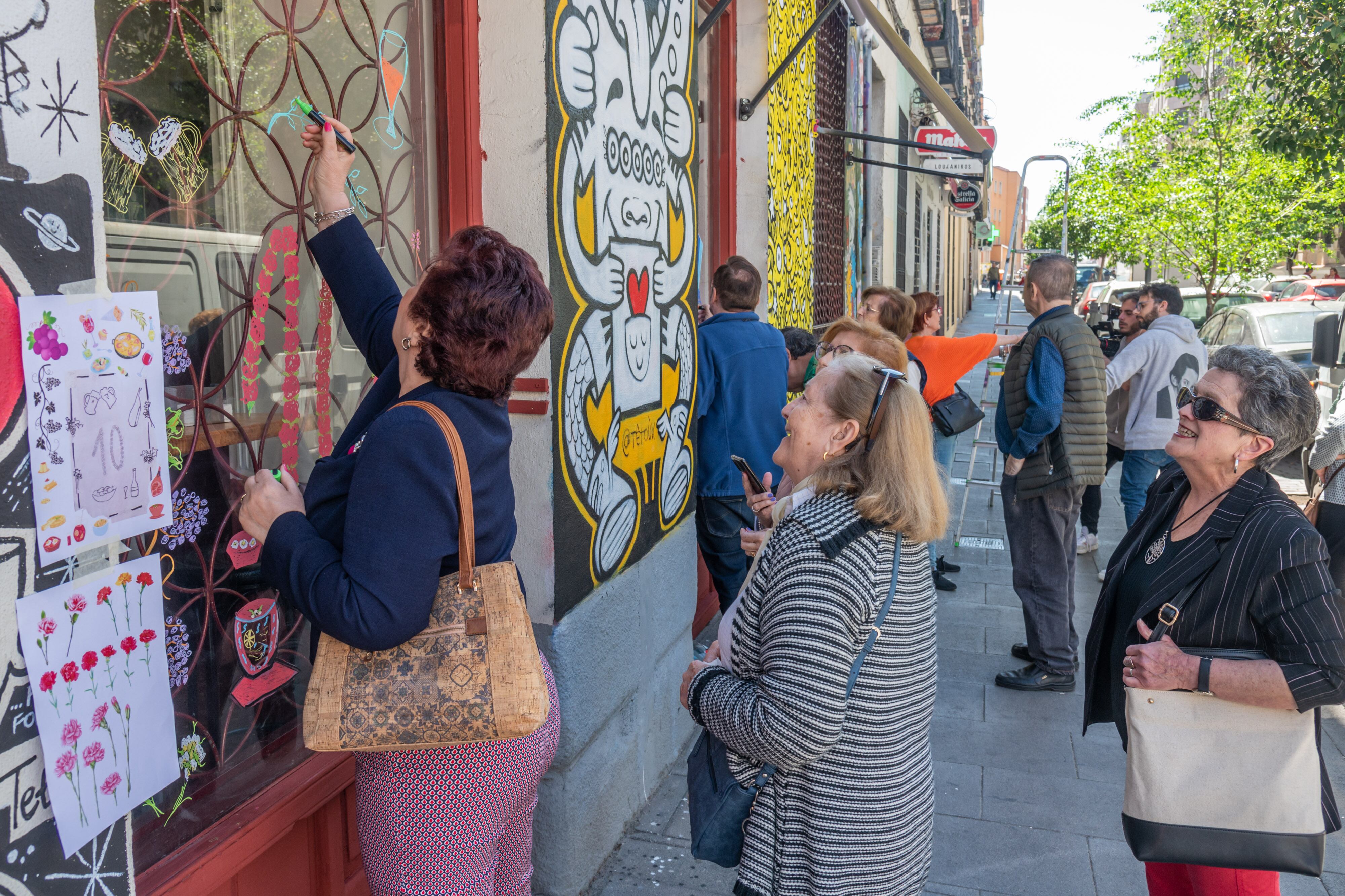 Varias de las participantes del Centro de mayores Antón Martín decoran las cristaleras de un bar de Lavapiés, en Madrid.