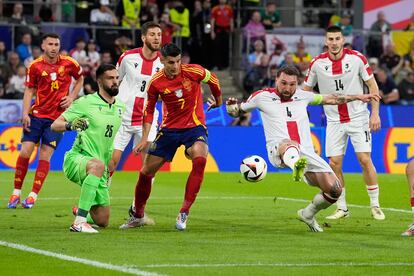  Guram Kashia de Georgia despeja un balón ante Álvaro Morata, de España.