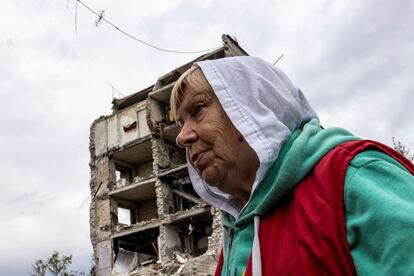 Una mujer delante del edificio destruido en el que tenía su apartamento, el martes.