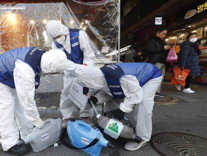 Un grupo de trabajadores rocía desinfectante en un mercado de Seúl este lunes.