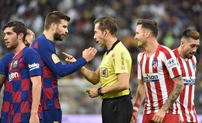 Piqué protesta al coleagiado González González durante la semifinal de la Supercopa de España que enfretó al Barcelona y al Atlético en Yedda.