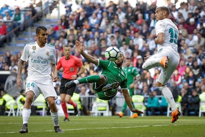El centrocampista francés del Leganés Nabil El Zhar golpea el balón ante el defensa del Real Madrid Theo Hernández (d) y el centrocampista madridista Dani Ceballos (i) durante el partido de la Liga Santander de fútbol disputado hoy en el estadio Santiago Bernabéu.
