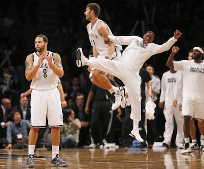 Deron Williams, Brook Lopez y Tyshawn Taylor celebran una canasta de Lopez en el último cuarto ante los Knicks.