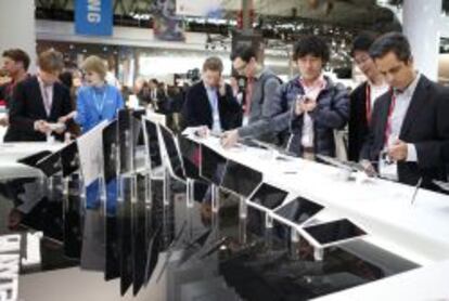 Visitantes del Mobile World Congress prueban diferentes artículos de Samsung.