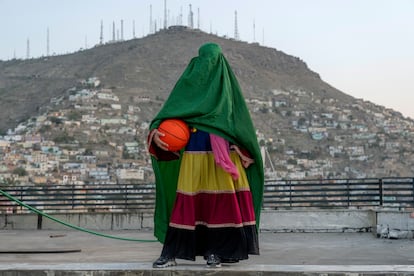 Una mujer afgana posa con una pelota de baloncesto en Kabul. Los deportes colectivos femeninos se han dejado de practicar. Incluso la capitana de la selección femenina de baloncesto en silla de ruedas se ha tenido que refugiar en España. Desde el exilio intenta mostrar al mundo la situación que están viviendo las mujeres en su país, hostigadas por el régimen.