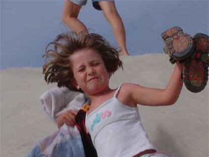 Una niña corre por las dunas