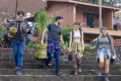 Young people carrying their backpacks and sleeping bags.