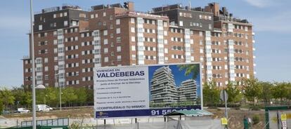 Cartel publicitario delante de una promoción de viviendas en régimen de cooperativa en Valdebebas (Madrid).