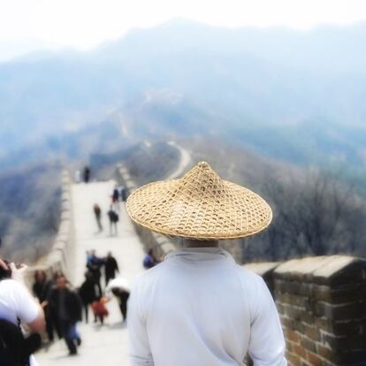 Un hombre con sombrero de paja en la Gran Muralla china.
