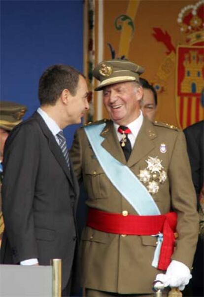 El Rey conversa con Zapatero, durante el desfile de la Fiesta Nacional.