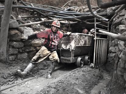 El minero Nelson Espinoza, de 33 años, arrastra un vagón junto a otros compañeros a la salida de un túnel de la mina.