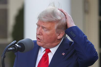 El presidente Donald Trump se sujeta el pelo el 30 de marzo de 2020.