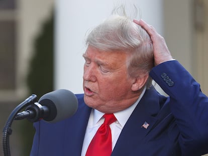 El presidente Donald Trump se sujeta el pelo el 30 de marzo de 2020.