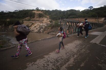 Una familia de migrantes que espera llegar a la lejana frontera de Estados Unidos camina por una carretera, en Jocotan, Guatemala, el sábado 16 de enero de 2021