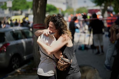 Dos mujeres lloran en una zona afectada por un ataque iraní en Tel Aviv (Israel), este domingo.