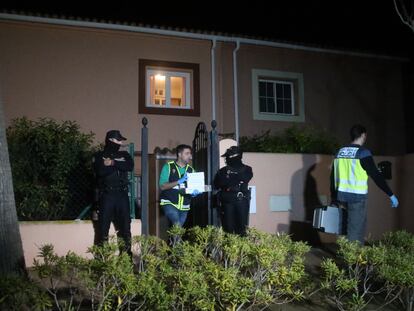 Un policía saca de la vivienda pruebas el domicilio en el que se han localizado los cadáveres del presunto asesino y de su pareja.