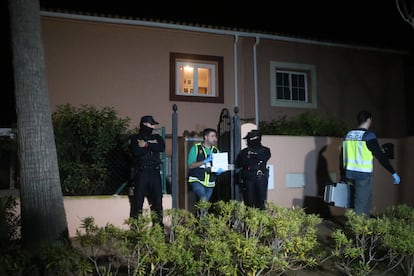 Un policía saca de la vivienda pruebas el domicilio en el que se han localizado los cadáveres del presunto asesino y de su pareja.