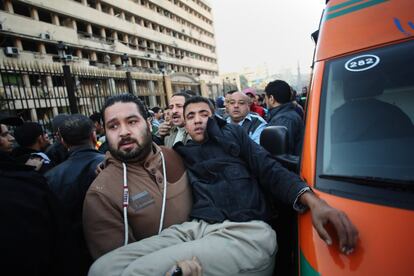 Un herido es evacuado tras la explosión del coche bomba contra la sede de la Policía en El Cairo (Egipto).