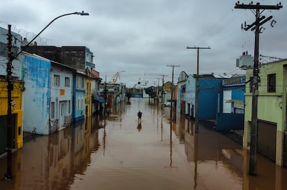 Un hombre camina por una zona inundada por fuertes lluvias, en Porto Alegre.