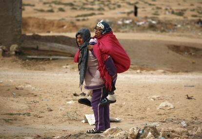 Una mujer transporta en la espalda a su madre, en Kasserine (Túnez), 28 de enero de 2016.