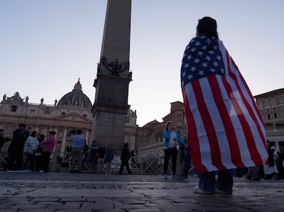 Andrea Gallardo, de 20 años, de Texas, lleva una bandera estadounidense después de que el Papa apareciera en el balcón de la Basílica de San Pedro tras su elección.