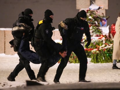 Varios policías detienen a un hombre que depositaba flores por Alexei Navalni en el monumento a las víctimas de la represión política de San Petersburgo, vigilado este viernes por un intenso despliegue policial.