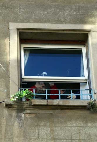 Miembros de la policía científica inspeccionan la ventana por la que un hombre ha arrojado a su madre en la calle Art de Barcelona.