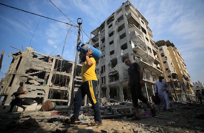 Los residentes de un barrio de Gaza inspeccionan los desperfectos causados por los bombardeos nocturnos de Israel.  