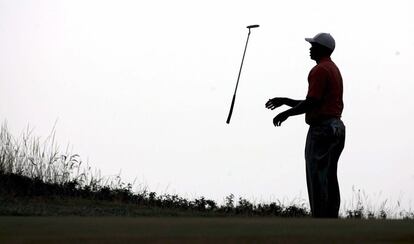 Tiger Woods lanza al aire uno de sus palos tras fallar un 'putt' durante la tercera jornada del Abierto Britnico de Golf, en el Royal Liverpool de Hoylake.