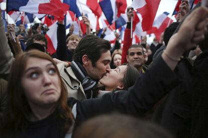 Simpatizantes de Emmanuel Macron, se besan mientras celebran el triunfo de su candidato a la presidencia de Francia.