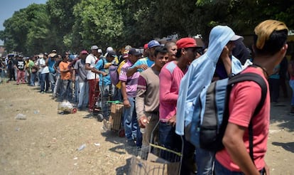 Decenas de migrantes venezolanos hacen cola para recibir comida en un refugio de Villa del Rosario (Venezuela).