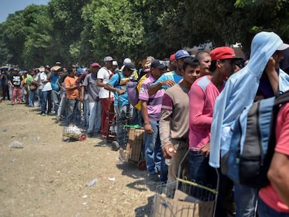 Decenas de migrantes venezolanos hacen cola para recibir comida en un refugio de Villa del Rosario (Venezuela).