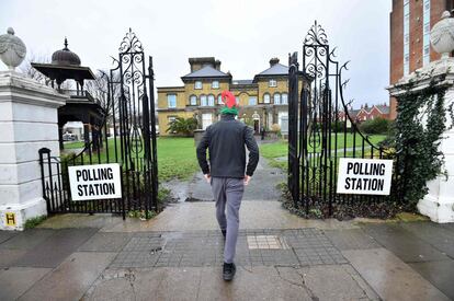 Un joven, con un gorro de Navidad, se dispone a votar en el Hove Museum & Art Gallery de Brighton (Inglaterra).