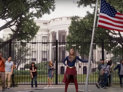 Supergirl con una bandera de EE UU frente a la Casa Blanca.