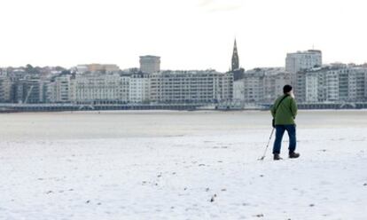 El temporal que vive la mayor parte de la Península Ibérica deja hoy estampas como esta, la playa de La Concha, en San Sebastián, cubierta de nieve