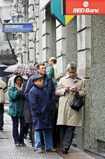 Ahorradores frente a un cajero automático en Montevideo.