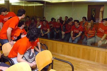 Los imputados de Jarrai, Haika y Segi en libertad saludan a sus compañeros presos (tras el cristal) durante el juicio