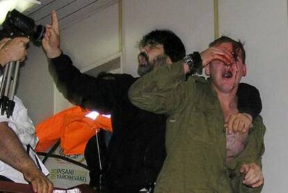 Un soldado israel herido, junto a una persona sin identificar, a bordo del <i>Mavi Marmara.</i>