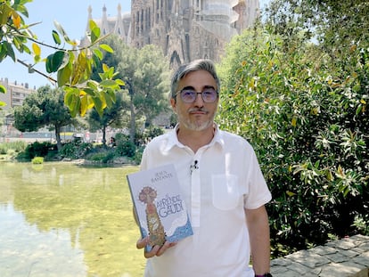 El periodista y escritor Jesús Bastante posa ante la basílica de la Sagrada Familia de Barcelona con un ejemplar de su última novela, en 2025.
