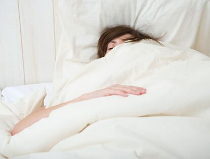 Una mujer duerme en su cama.