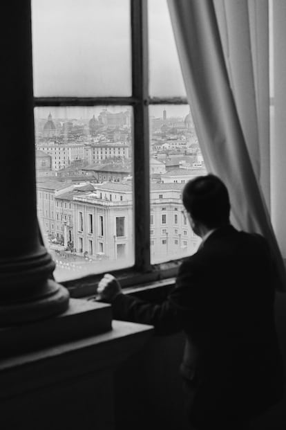 El escritor contempla Roma desde una ventana del último piso del Palacio Apostólico del Vaticano, que se alza sobre la plaza de San Pedro.