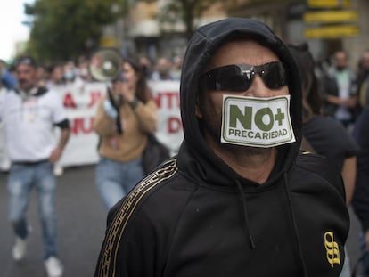 Un trabajador se coloca una pegatina de 'No más precariedad' durante la manifestación del metal en Cádiz.
